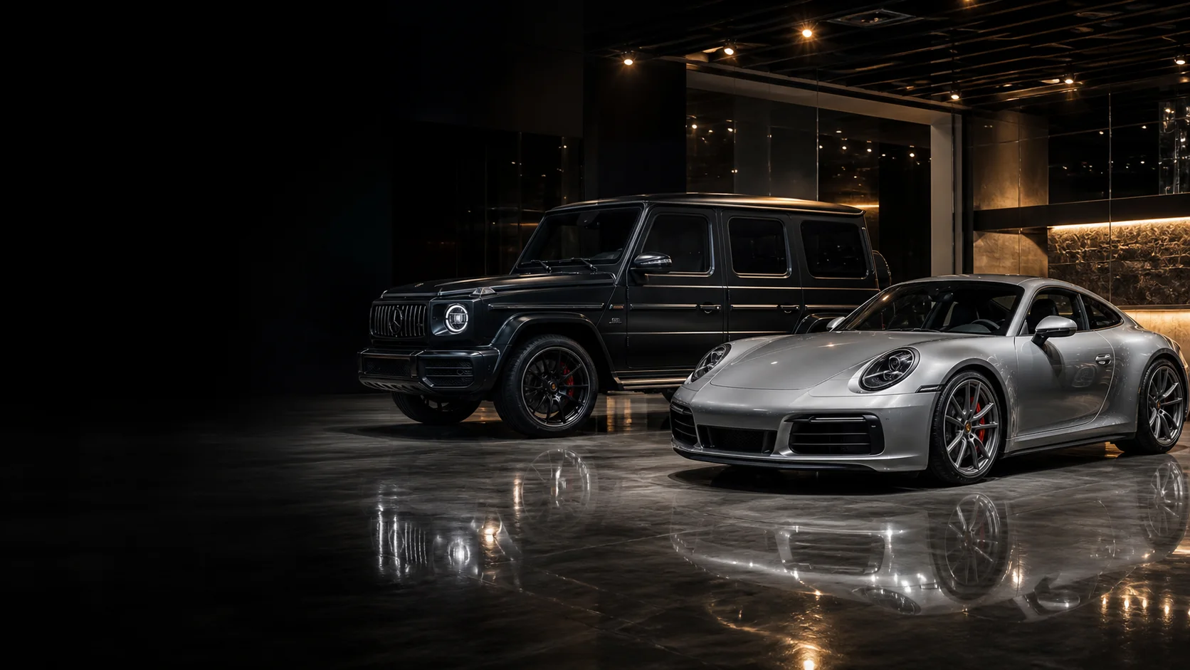 夜の高級車ショールームに並ぶシルバーのスポーツカーとブラックのSUV